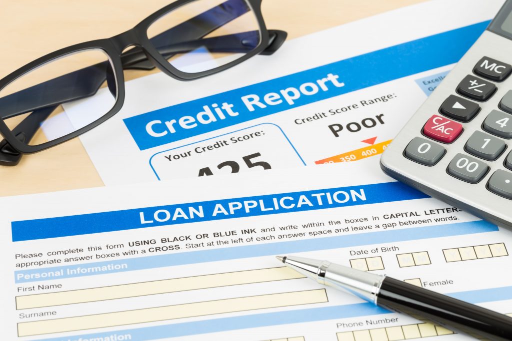 Credit Report, loan application, pen, calculator, and eye glasses